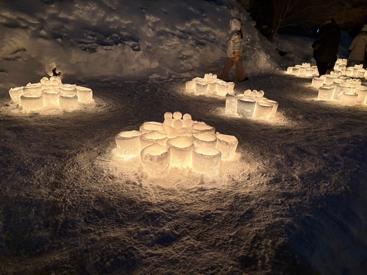 雪の上に花の形に並べられ灯りがともる雪のキャンドル、おたる雪あかりの路の夜