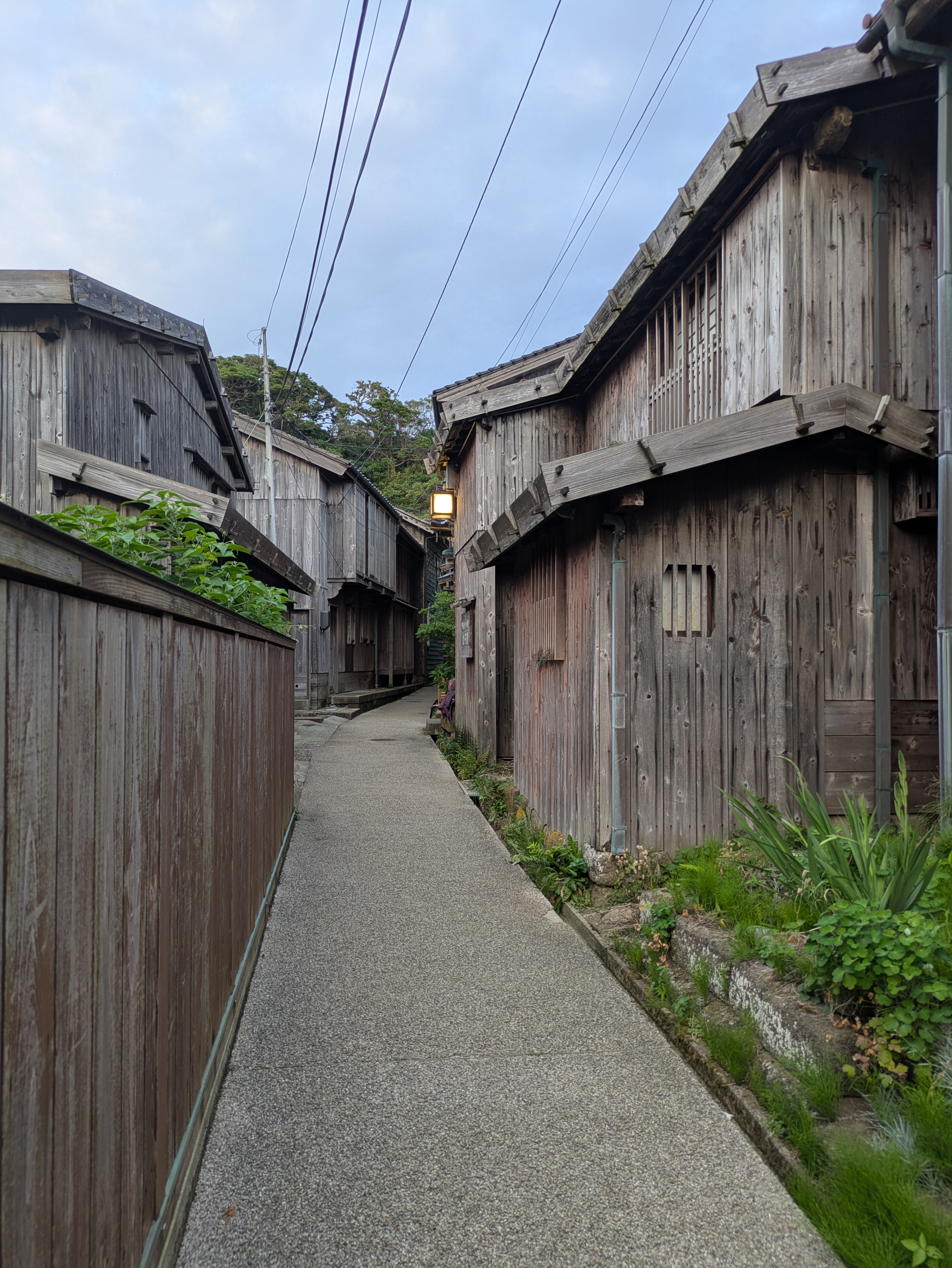 板張りの木造家屋が建ち並ぶ佐渡島・宿根木集落の細い路地