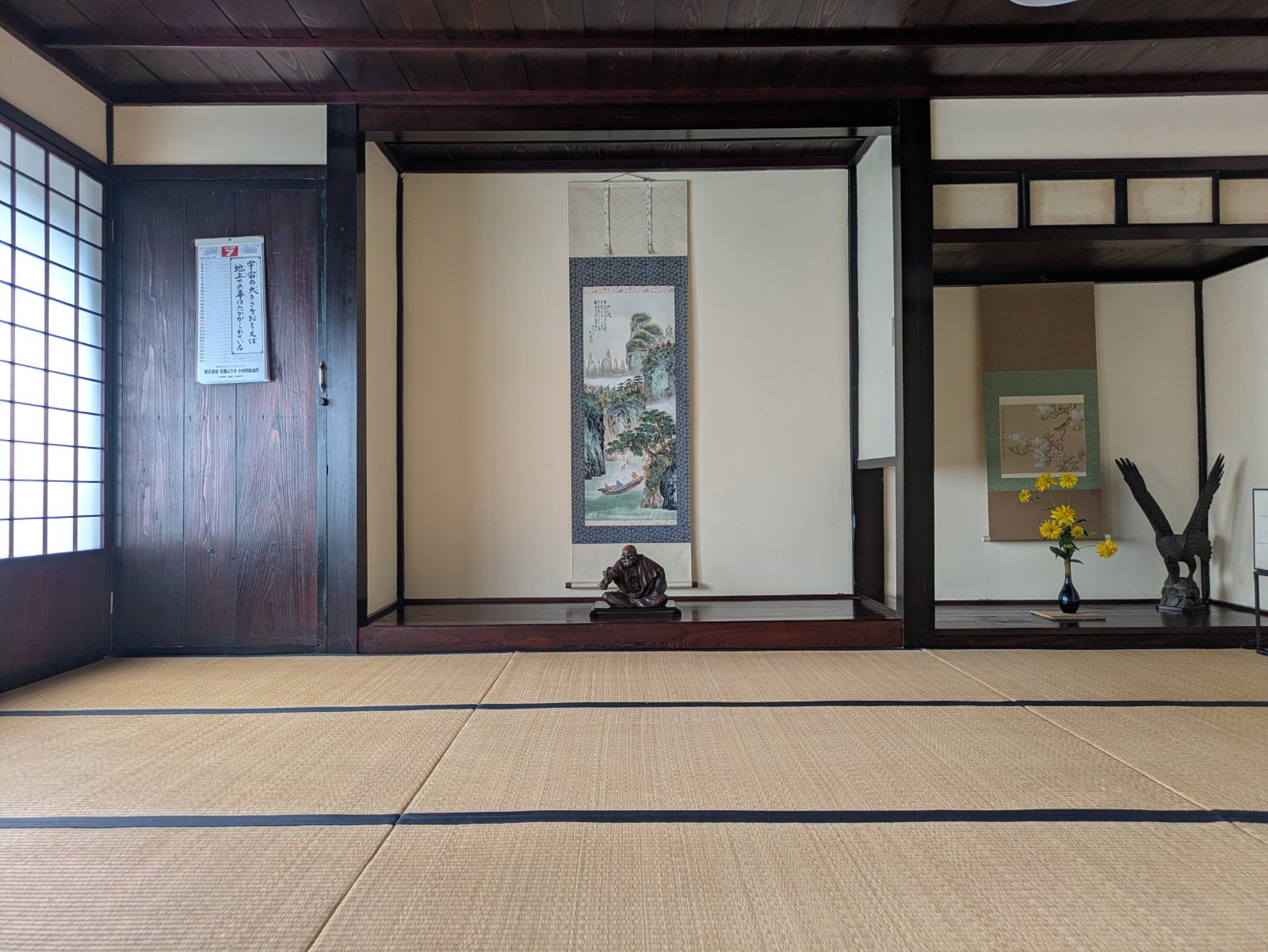 掛け軸と置物が飾られた床の間のある宿根木の古民家の畳の和室