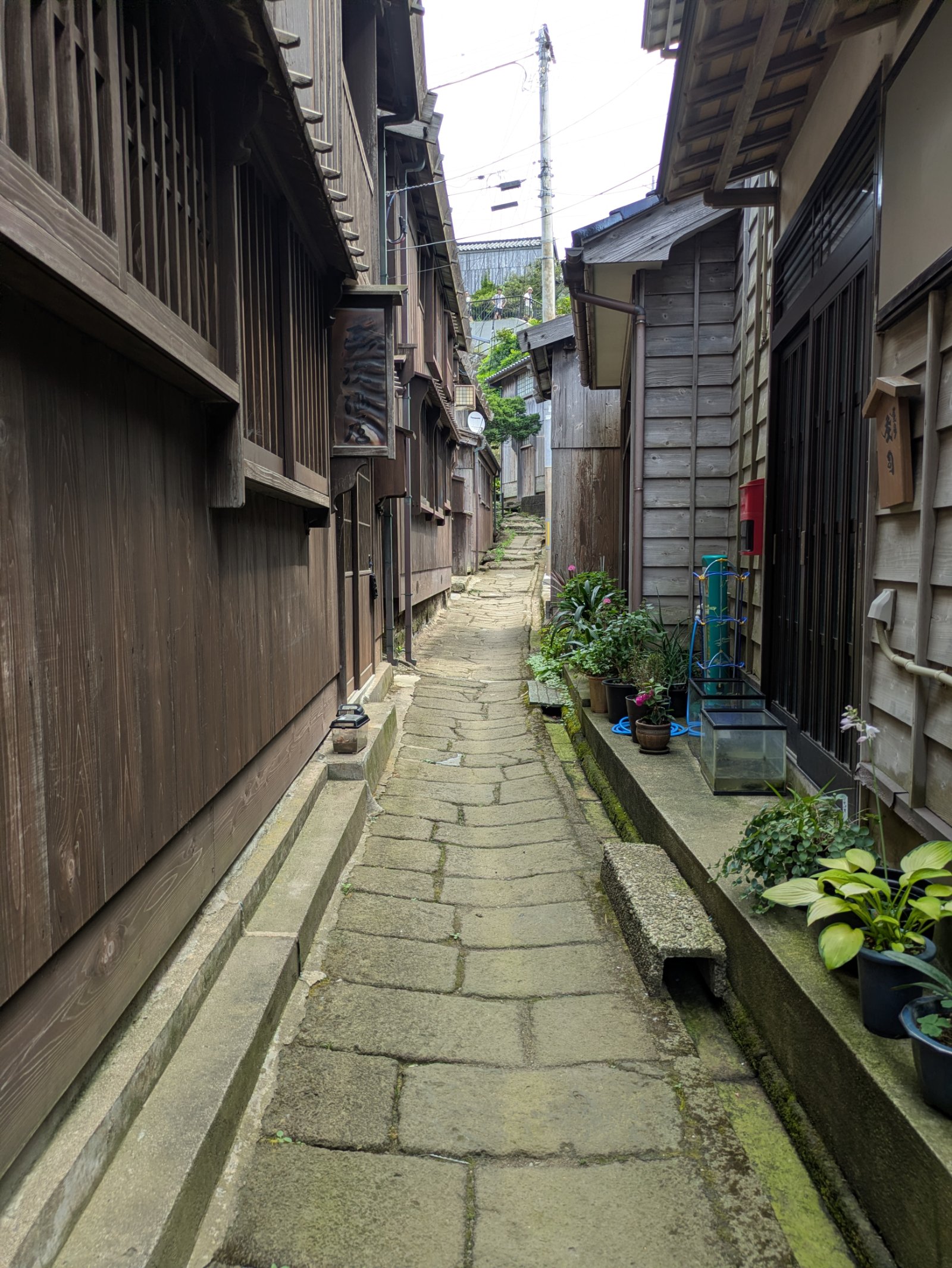 板張りの木造家屋が両側に並ぶ宿根木集落の細い石畳の路地