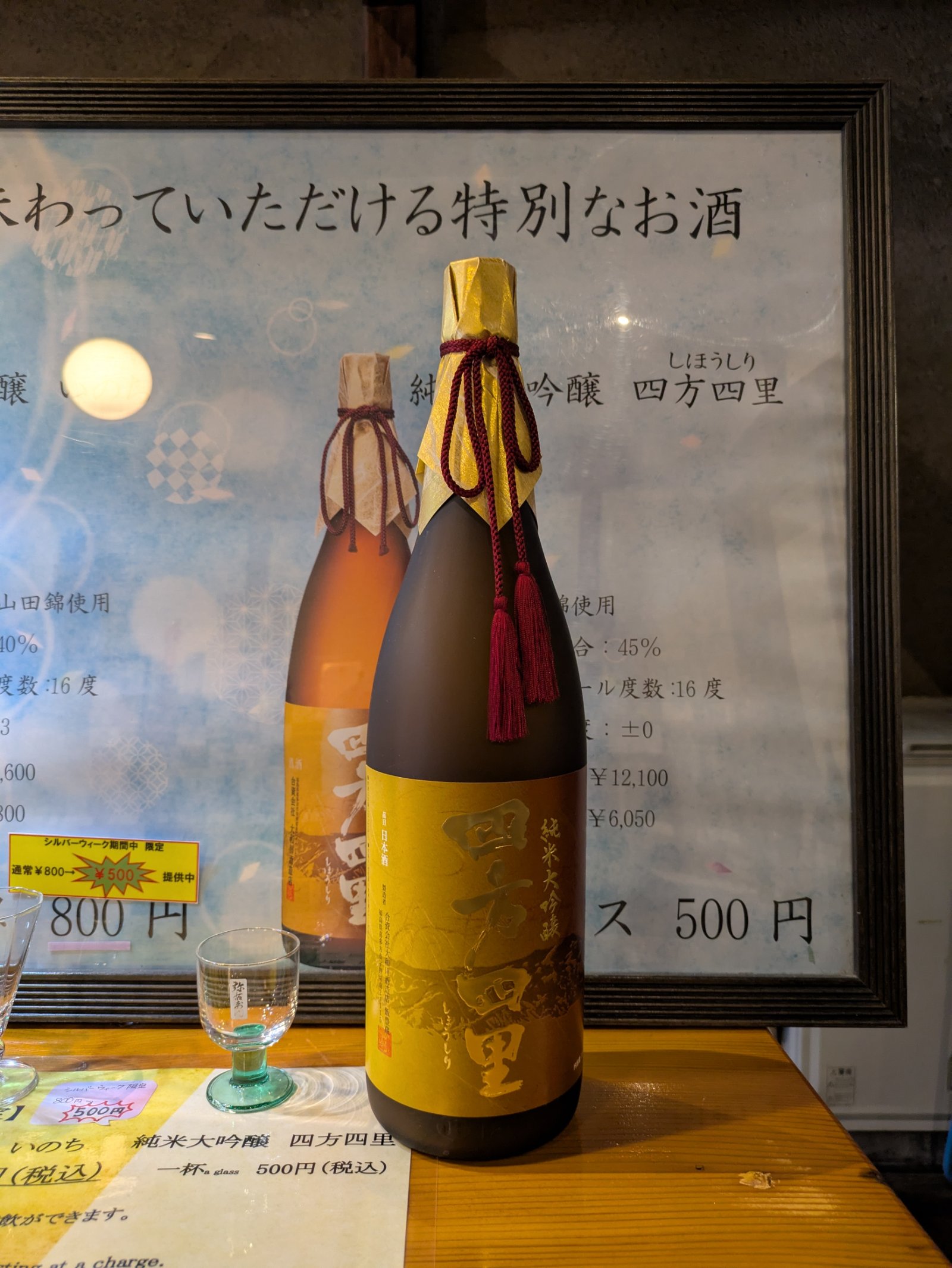 試飲台に置かれた純米大吟醸「四方四里」の一升瓶と、1杯500円の案内板