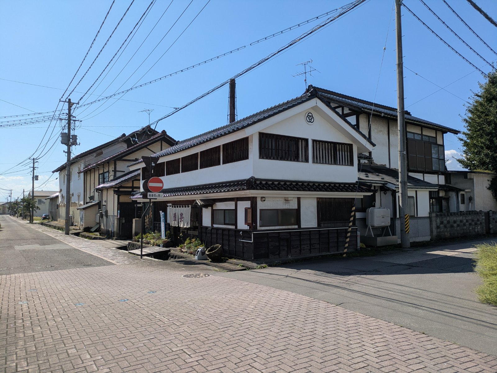 晴れた日の喜多方の通り沿いに並ぶ白壁と黒板張りの蔵造りの建物
