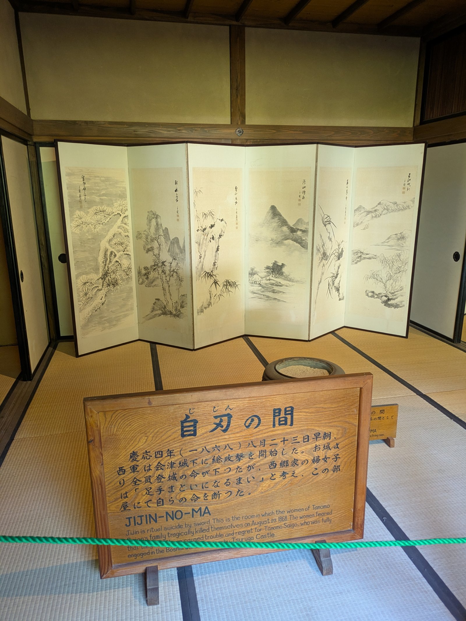 武家屋敷の自刃の間、水墨画の六曲屏風と西郷家の婦女子の自刃を伝える説明板
