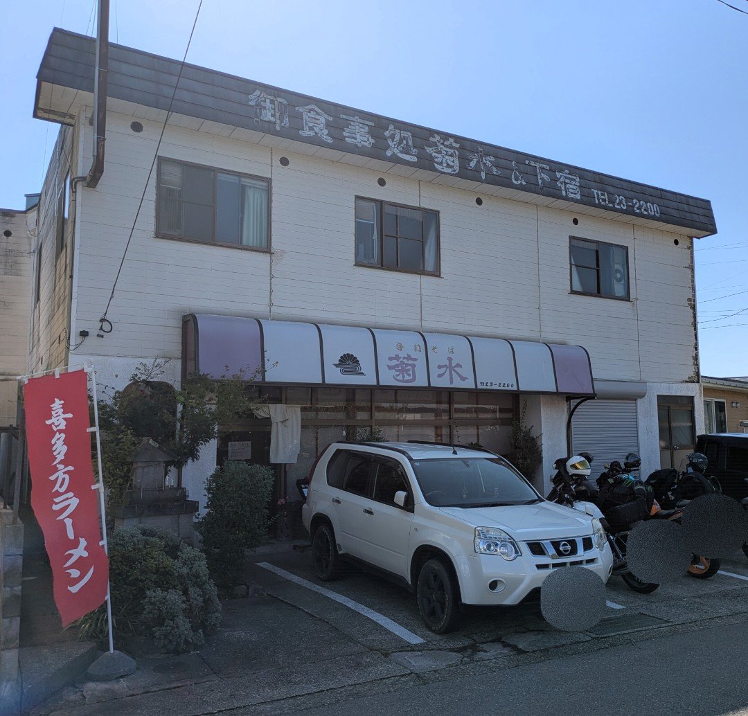 「喜多方ラーメン」ののぼりが立つ菊水の二階建ての店舗と、店前に停まる車やバイク