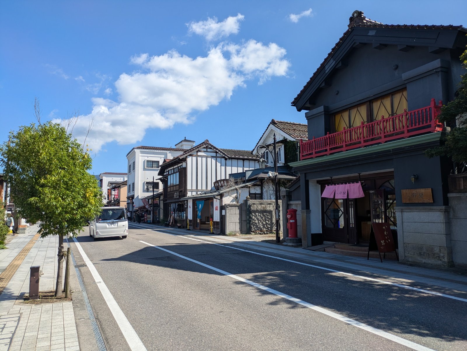 青空の下、蔵造りや洋風の古い建物が並ぶ会津若松・七日町の通り