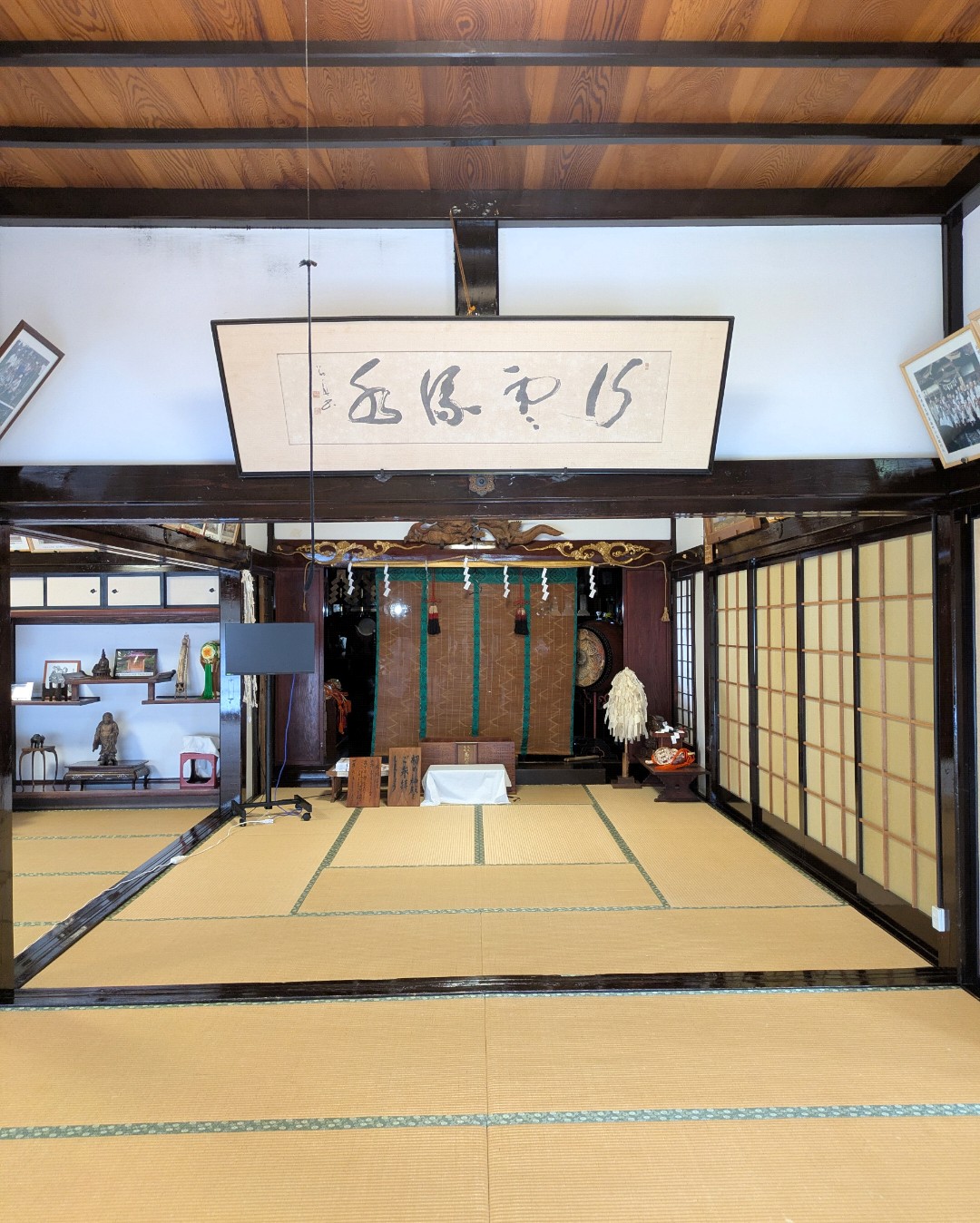 大進坊の祈祷を行う畳敷きの広間と、奥に祭壇、天井下に掲げられた書の額